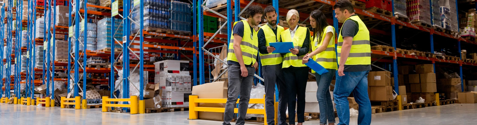 Workers reviewing shipping and receiving manifest in warehouse